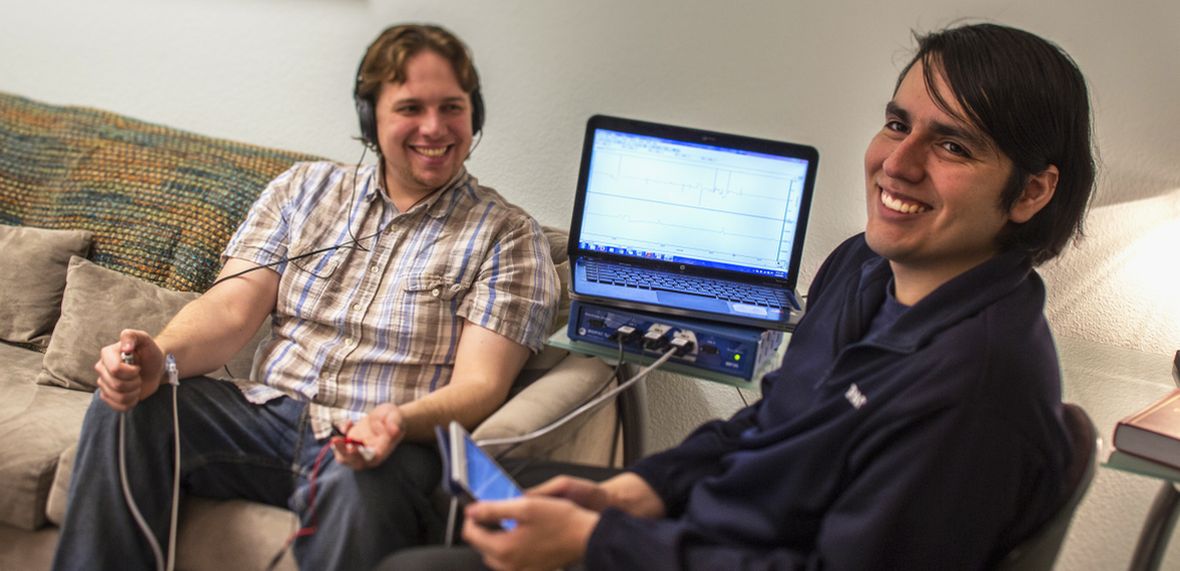 A graduate student conducts social-psychology research with a human subject using a computer-based sensor