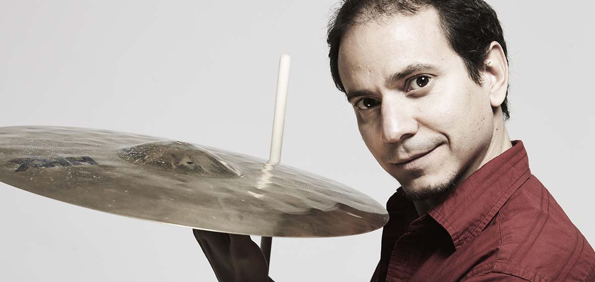 Dafnis Prieto poses with a cymbal in hand