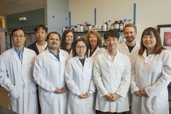 A representative of YUYANG is posing with Dr. Ro and 7 members of his laboratory team