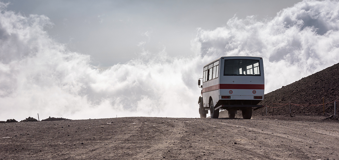bus driving away on dirt road