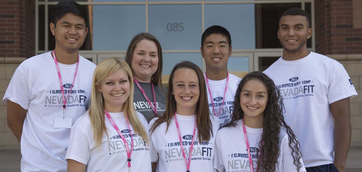 Seven students in white NevadaFIT T-shirst pose for a photo while gathered on the University of Nevada, Reno campus.