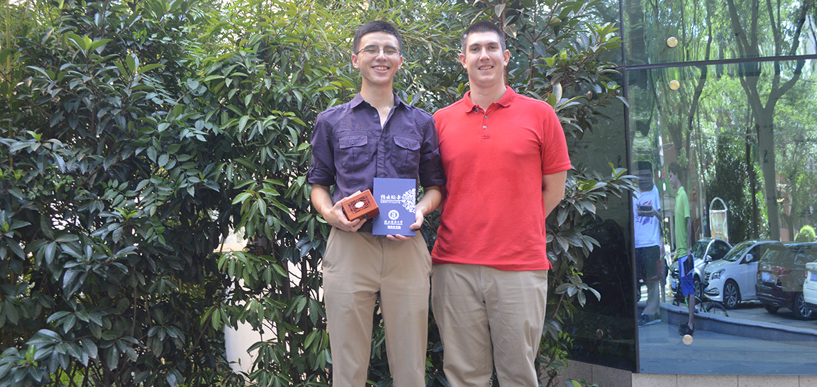 Daniel Lang holds award next to fellow student