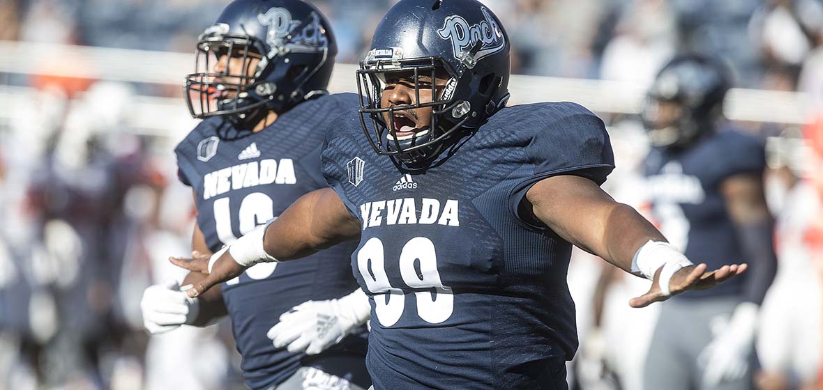 Two Wolf Pack football players on the field during a game