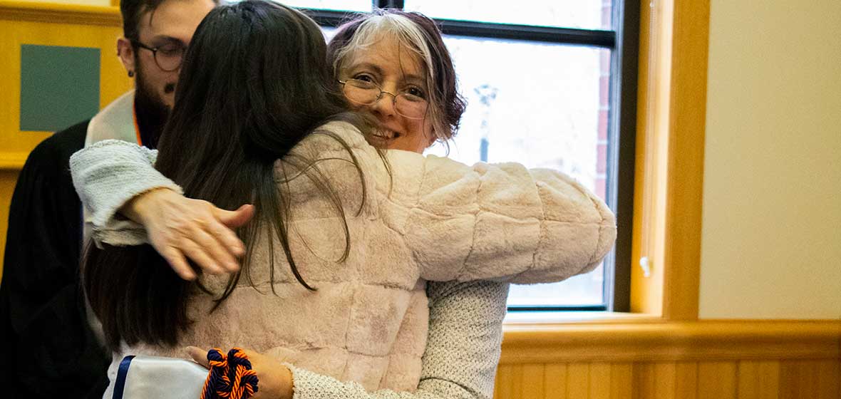 A woman hugs another lady. 