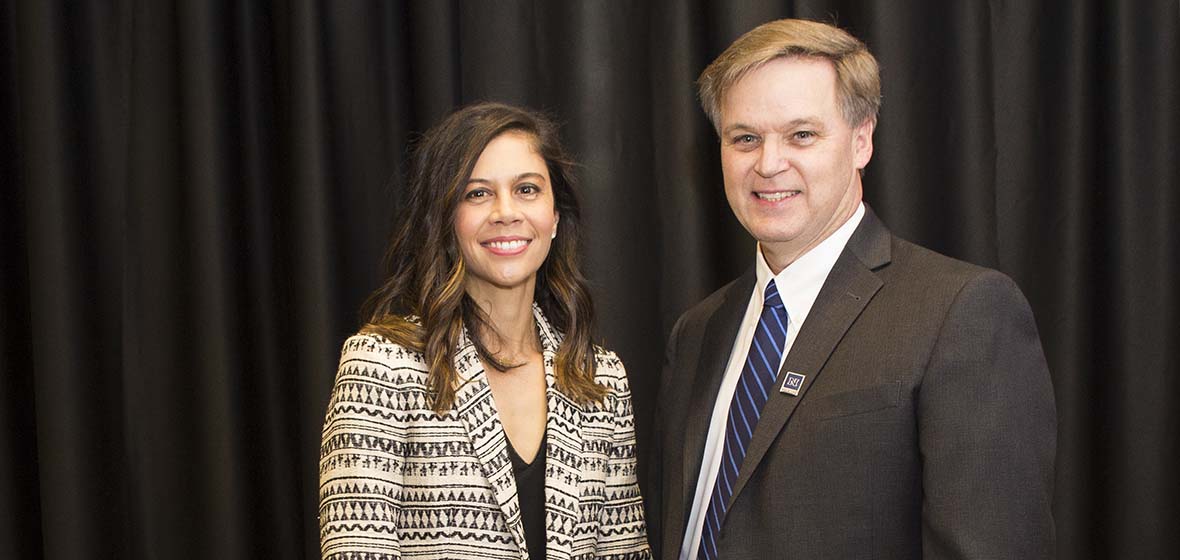 Lori Rawson and James Harris pose in front of a black drape