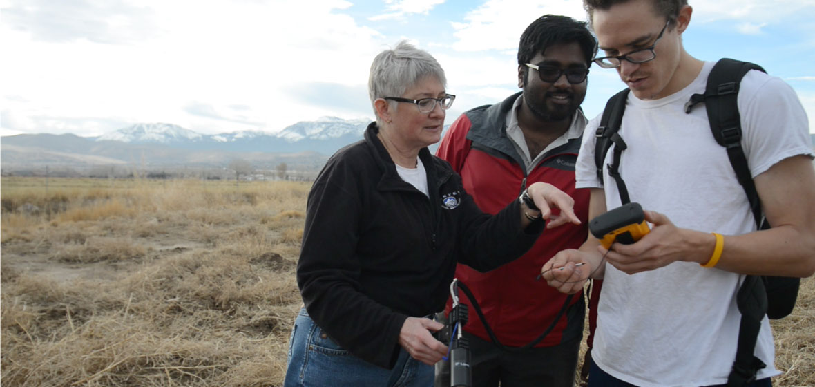Professor Wendy Calvin with two students using a portable field spectrometer.