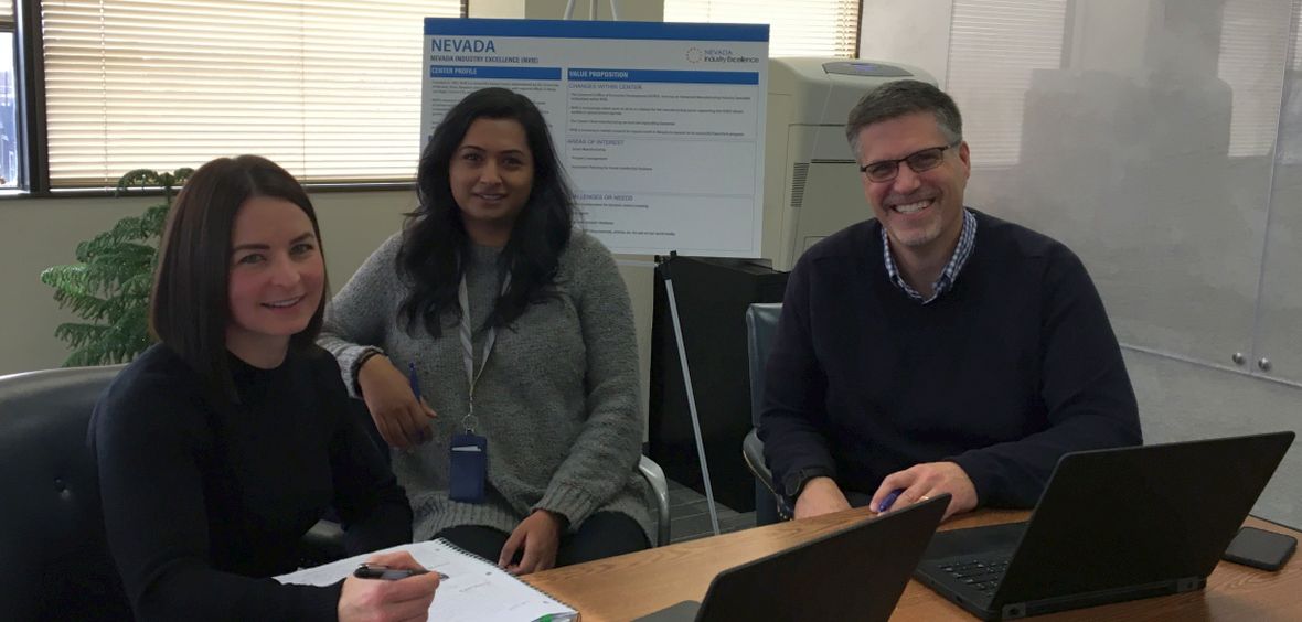 Two Nevada Industry Excellence staff members meet in the office with Director Mark Anderson.