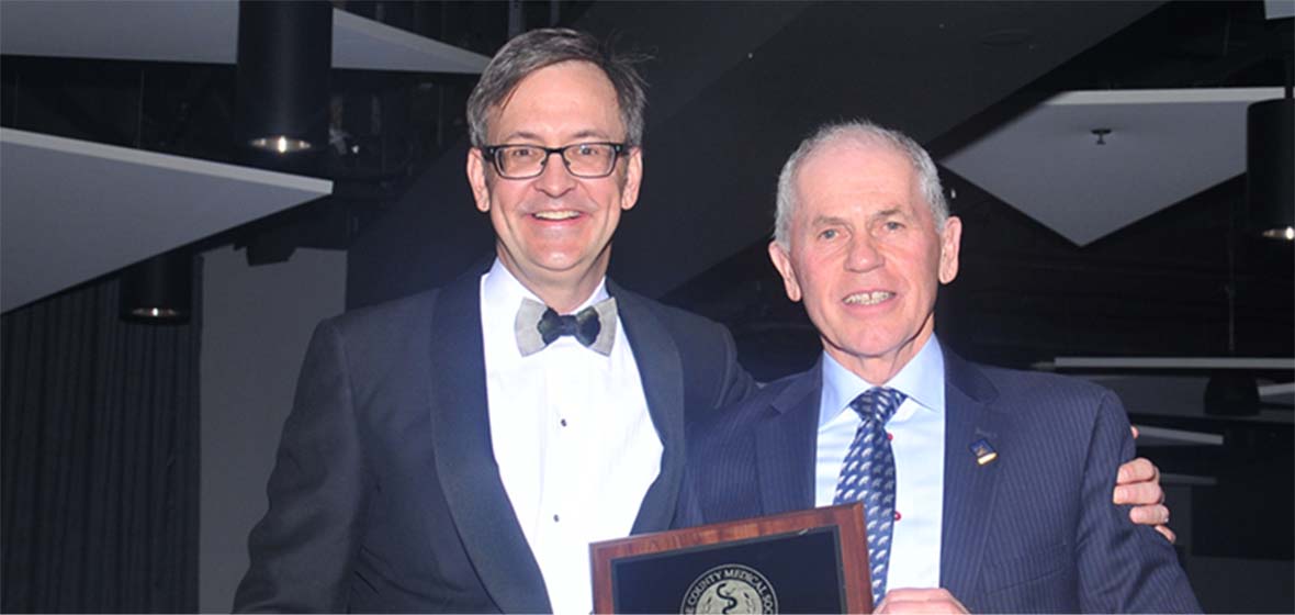 Washoe County Medical Society President Andrew V. Pasternak, IV, M.D. (left) presents University of Nevada, Reno School of Medicine Dean Thomas L. Schwenk, M.D. (right) with a Community Service Award that recognizes UNR Med's community engagement and contributions.
