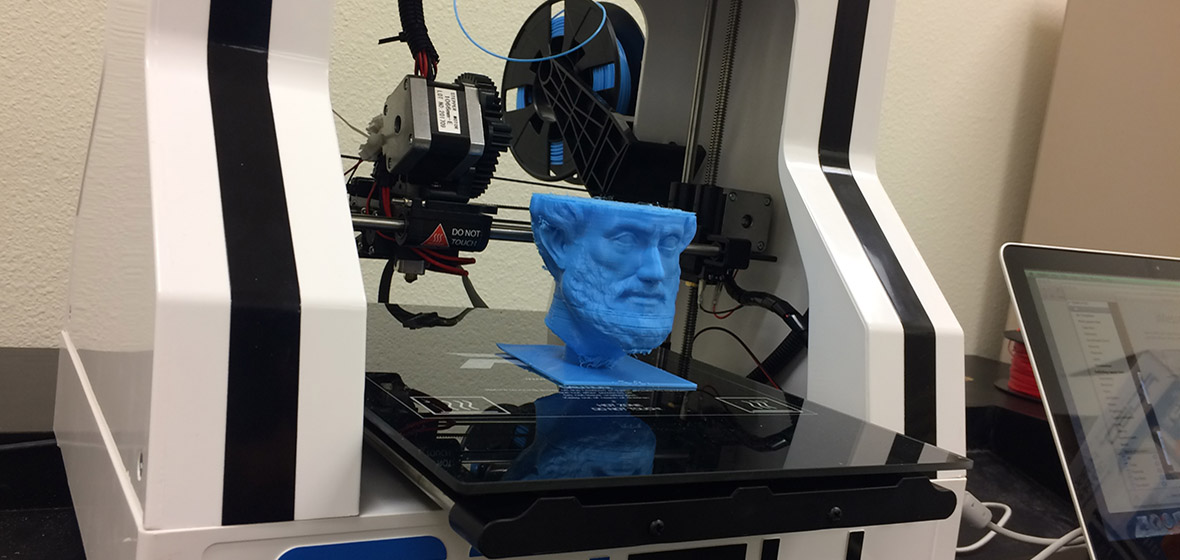 blue 3D printed bust sitting on a 3D printer