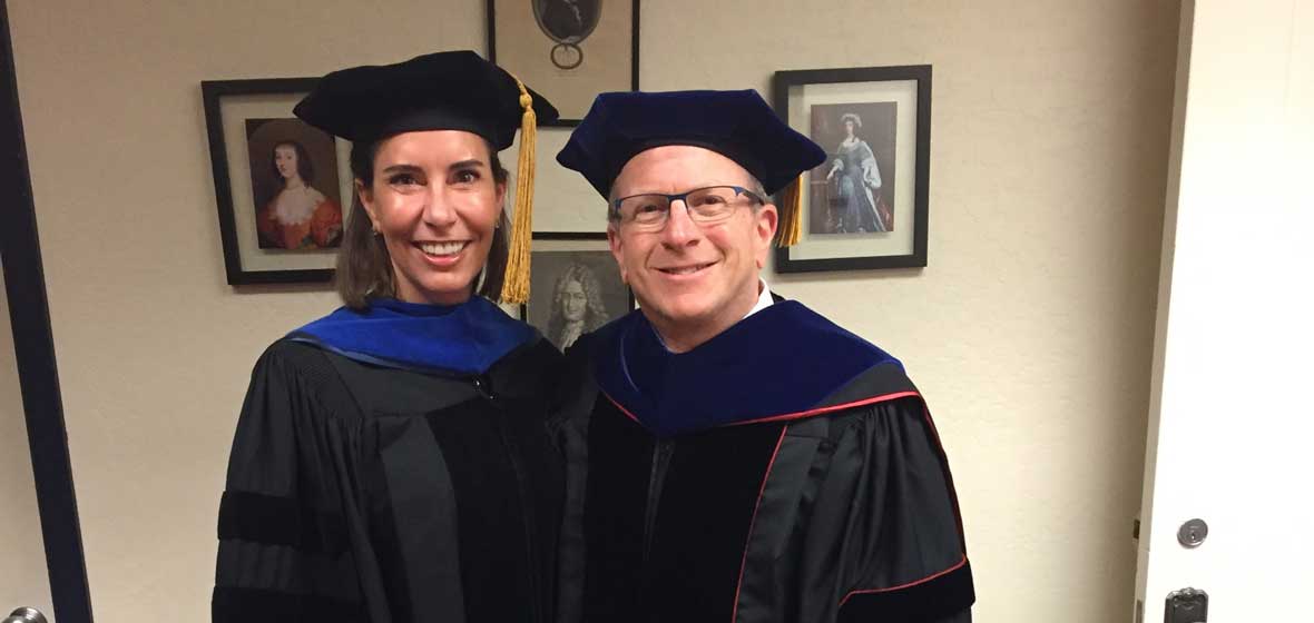 A man and a woman in graduation robes. 