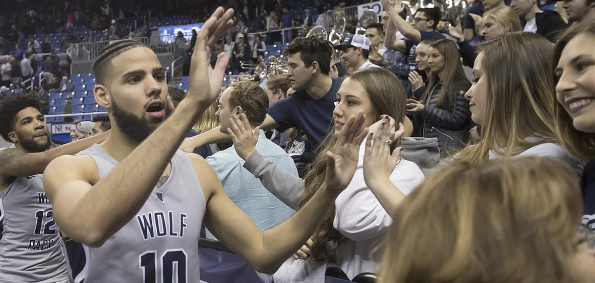 Caleb Martin high fives fans at Lawlor Events Center