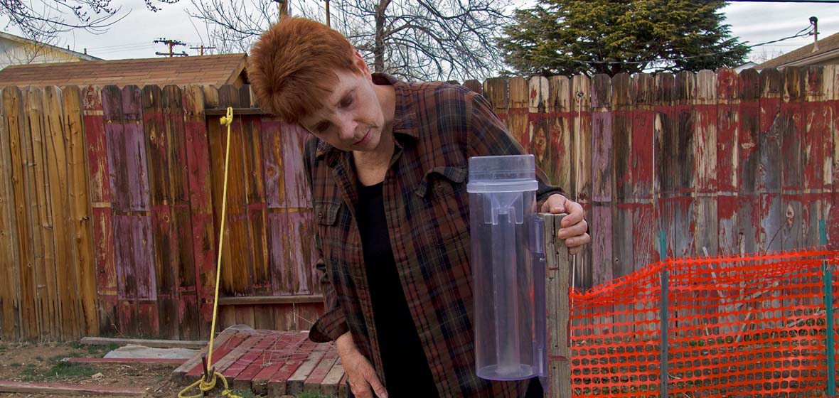 Woman holding a rain gauge