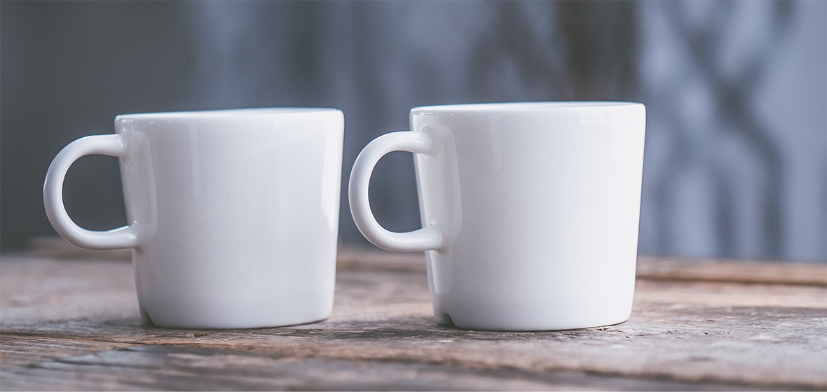 Two coffee mugs on a wooden table