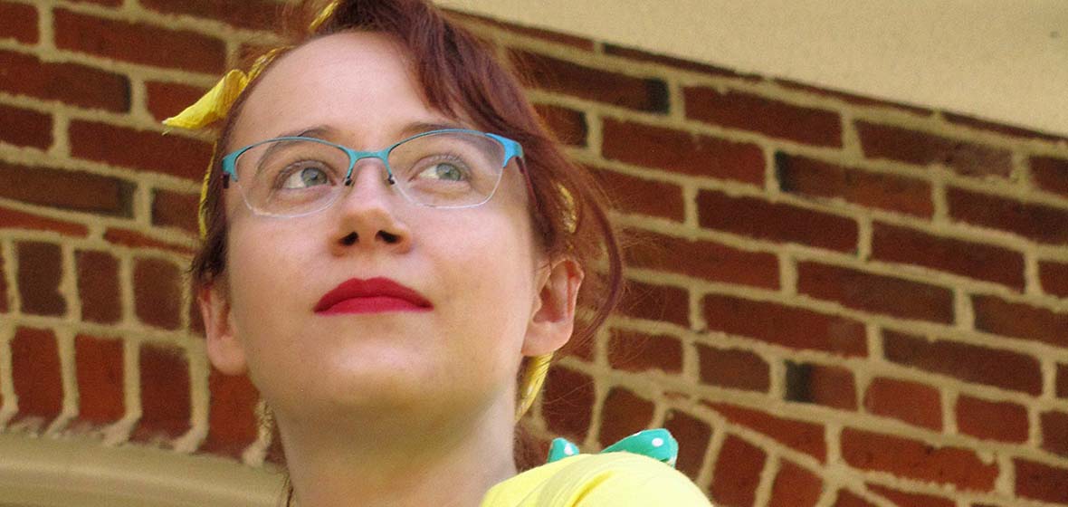 Allison Blair looks pensive with brick wall behind her