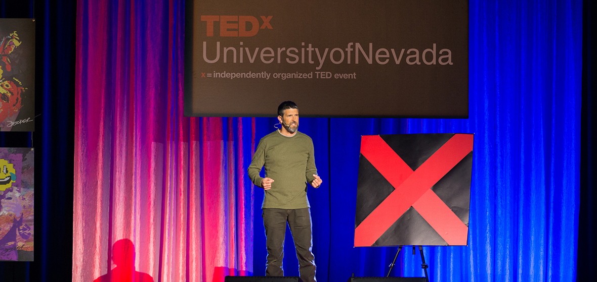 Tony Lillios speaking on stage at TEDxUniversityofNevada 2018.