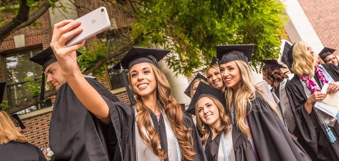 Graduates taking selfies at commencement