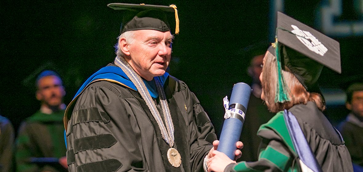 President Johnson shakes hands with a UNR Med graduate