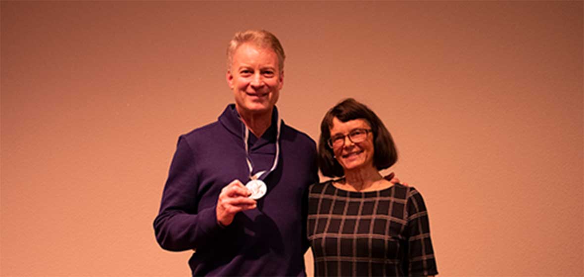 A man and a woman stand on stage. 