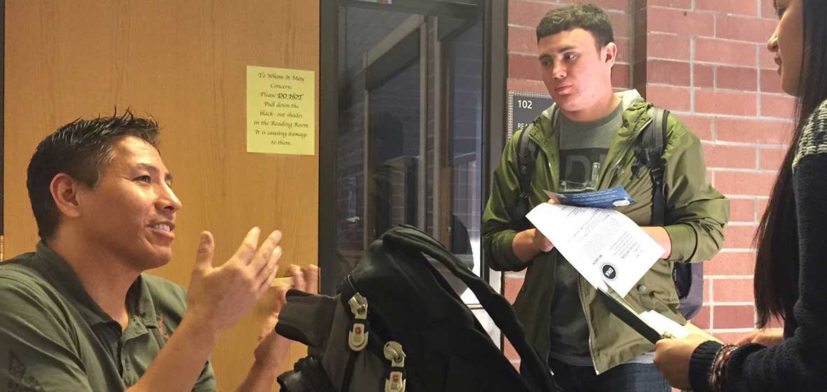 A man sits in front of two students