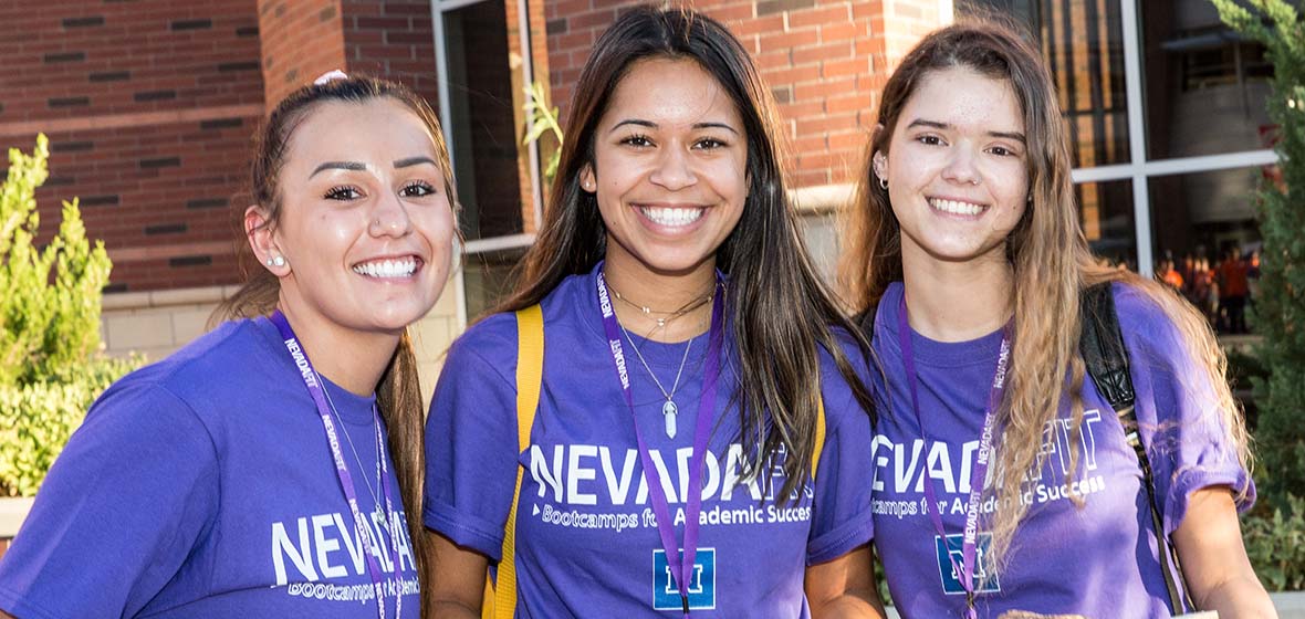 Three freshmen in purple NevadaFIT T-shirts pose for a photo. 