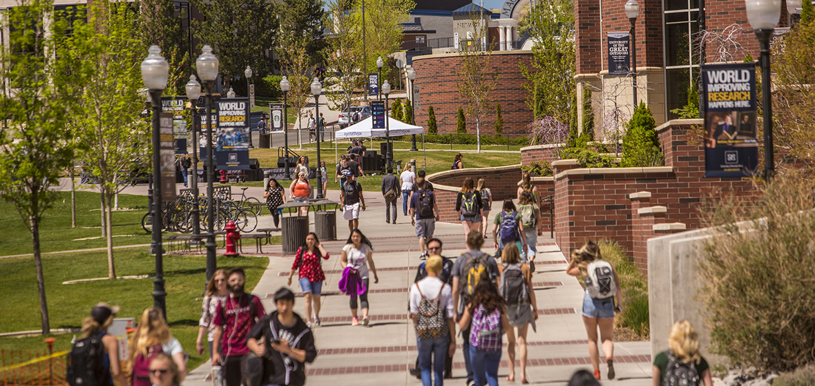 Image of students walking on campus in front of the Mathewson-IGT Knowledge Center looking north. 