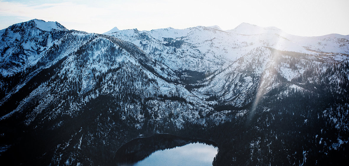 Image of a lake at the base of snowy mountains. 