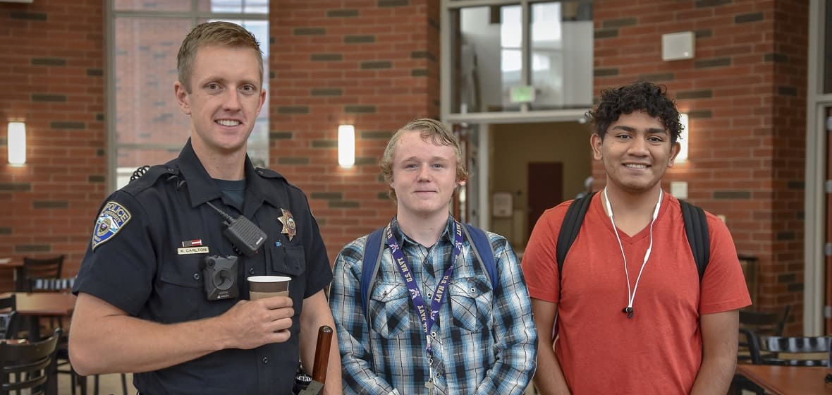 A University police officer stands with two students. 