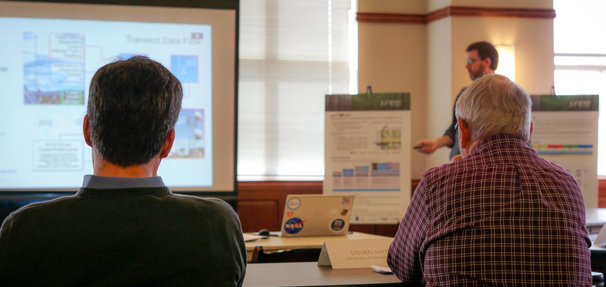 Vice Provost Steve Smith and Juniper Networks Board Member listen to Dr. Scotty Strachan as he presents information