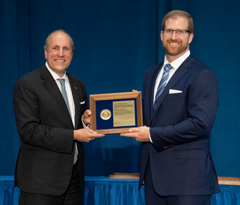 Rick Kraus stands with Undersecretary of Science at the Department of Energy, Paul Dabbar to accept his award.