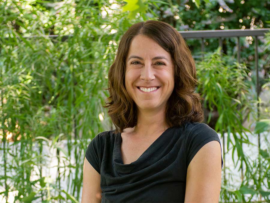 Headshot of Erica Bigio in front of foliage 