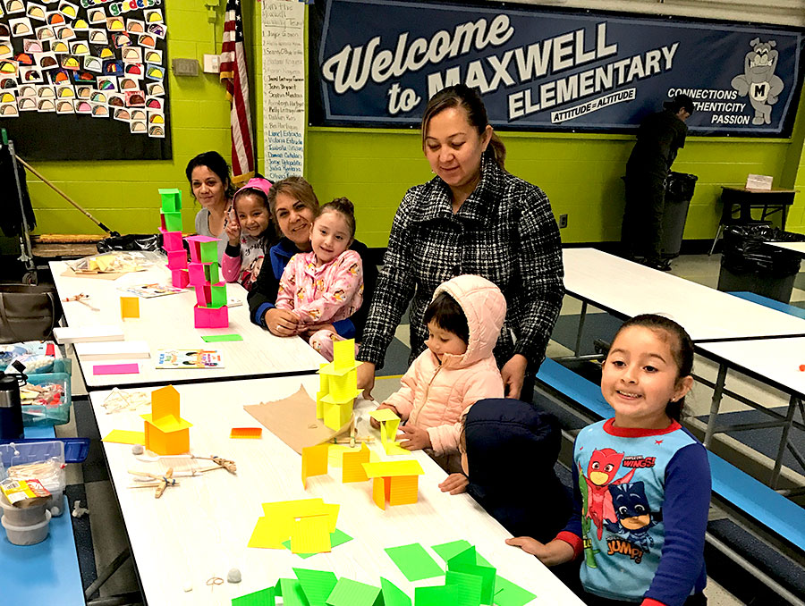 Parents and children building towers with index cards