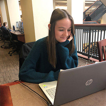 Jordan Nicholson studying with a laptop