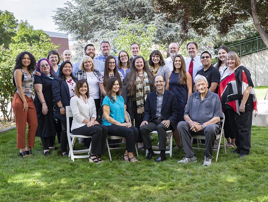 A group of KUNR staff pose outdoors.