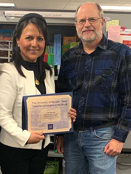 Lizeth holding her award standing next to her boss Daniel Weigel