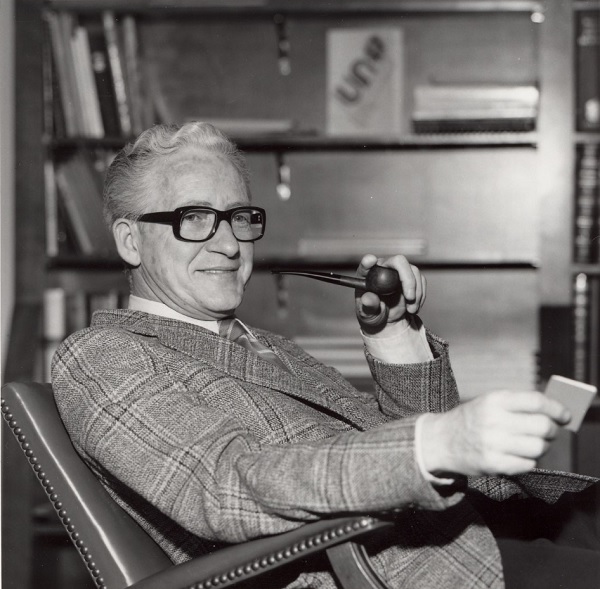Max C. Milam, President of the University of Nevada from 1974-1978, is seen here smoking on a pipe in his office.
