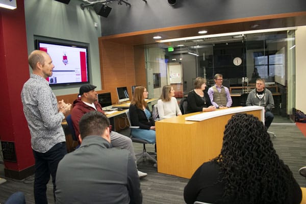 Professor Colombant addresses the crowd at a podcasting event.