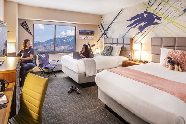 Students pose in a staged room in Wolf Pack Tower