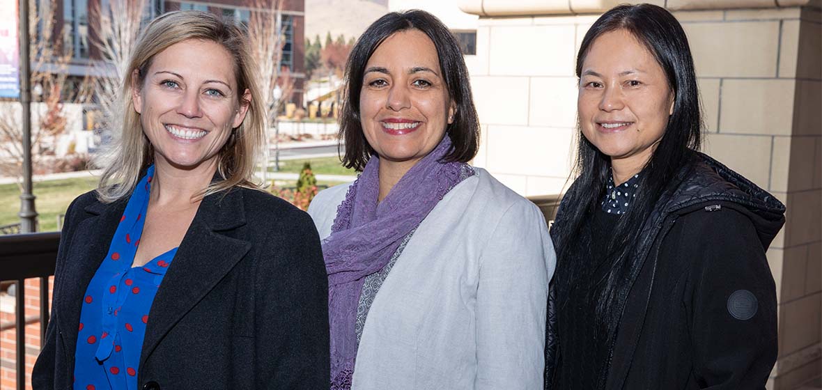 Kathy Hanselman, Lia Schraeder and Wenzhen Li standing in front of the Knowledge Center with the Fitness Center in the background