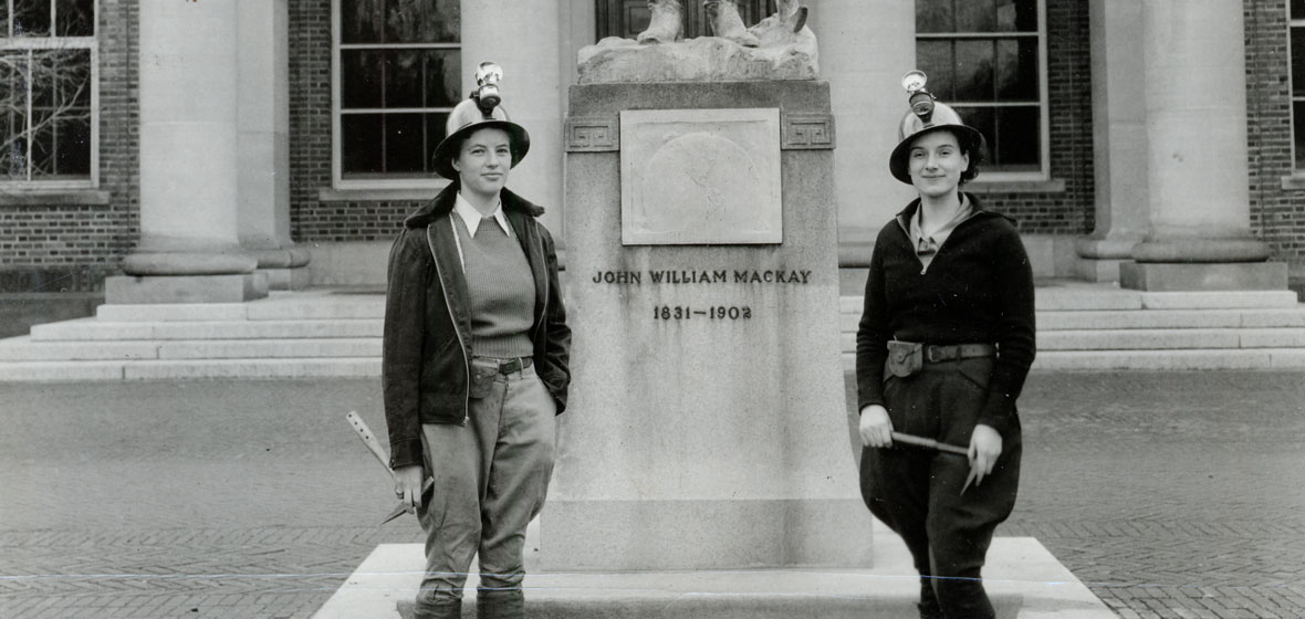 old photograph of two women in front of Mackay Statue