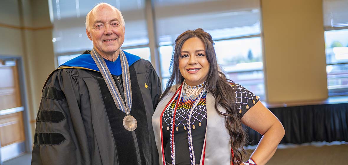 University of Nevada, Reno President Marc Johnson and recent alumna Christina Thomas celebrate the American Indian & Alaska Native Graduate Celebration in May 2019. Johnson is wearing commencement regalia, and Thomas is in traditional Paiute garb.