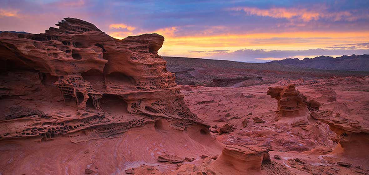 A sunrise over some red rocks in the Mojave Desert.