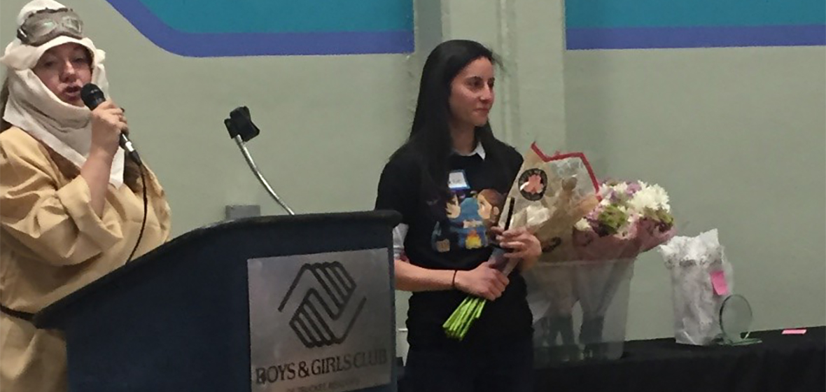 Jacqueline Kirshenbaum stands to receive award and flowers