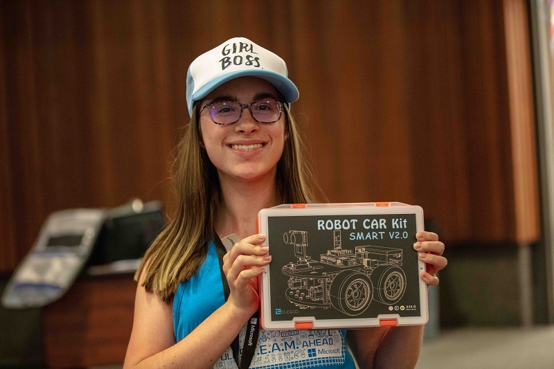 Digigirlz camp member wearing a hat that says girl boss and is holding robot car kit