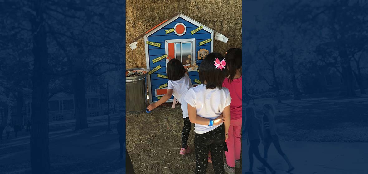 girls playing a bean bag toss game called the Ember House