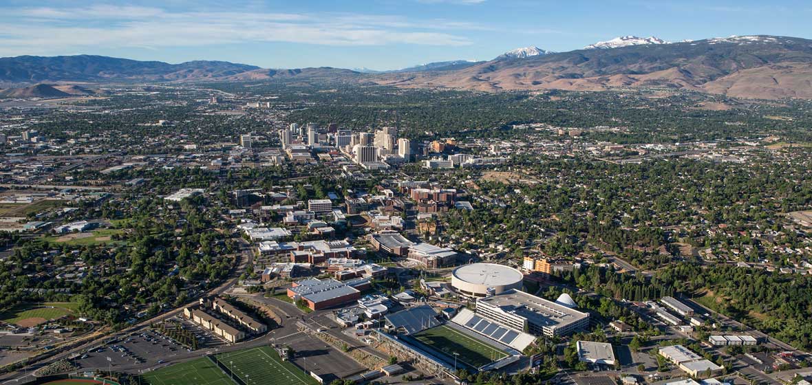 An area shot of the University and the surrounding parts of the city and mountains.