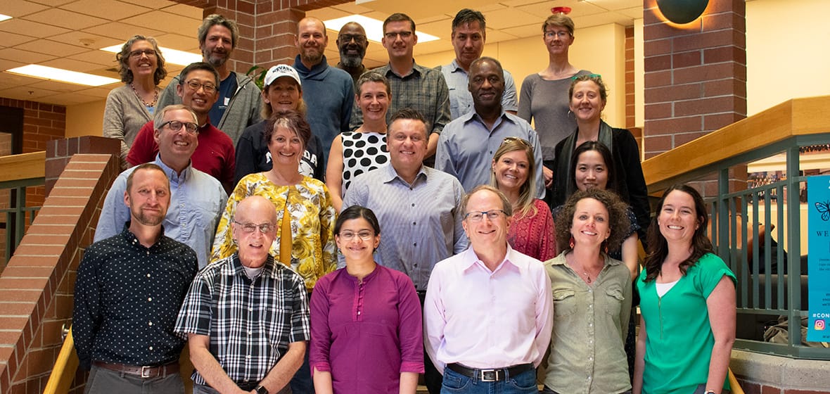 A group of faculty pose indoors.