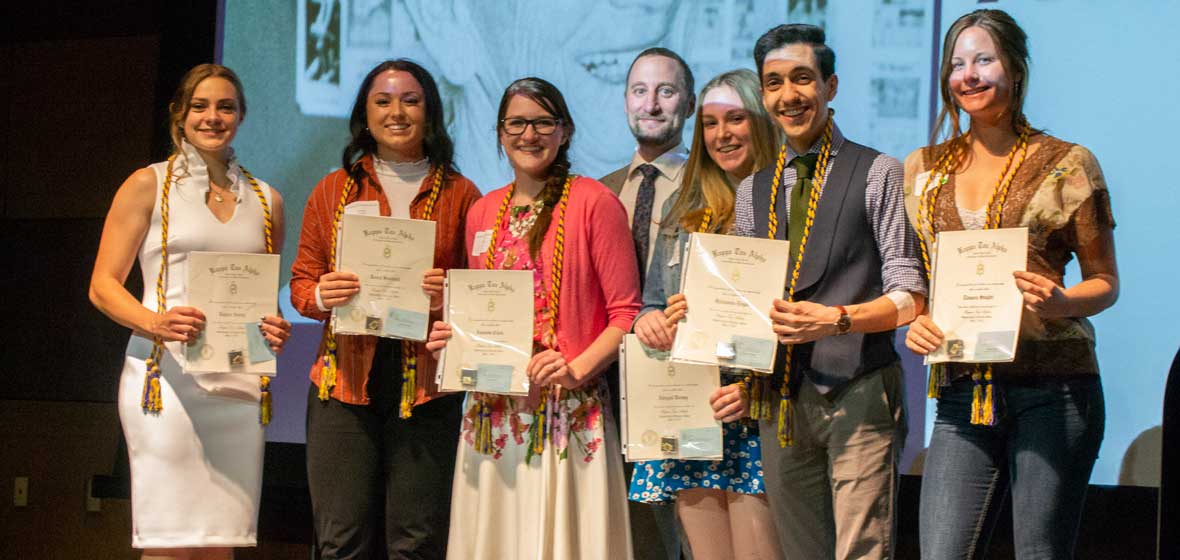 A group of people on a stage, all holding awards. 