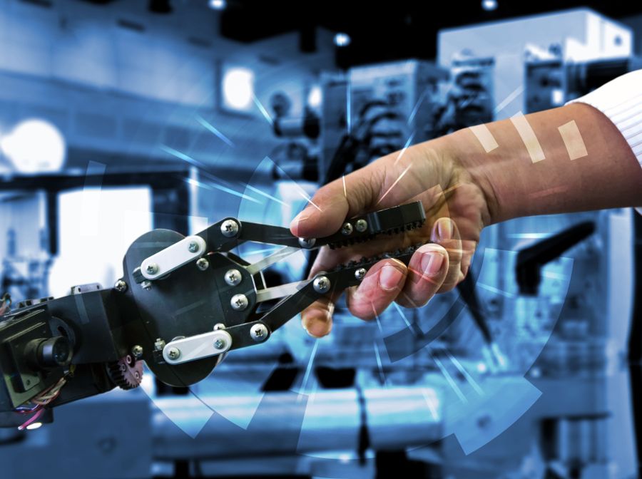 A robot shaking hands with a human hand in a manufacturing setting