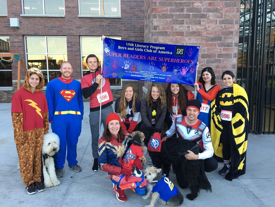 The literacy program team posing dressed as superheroes