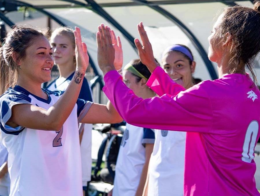 Two Nevada Wolf Pack Women's Soccer Players give each other a double high-five